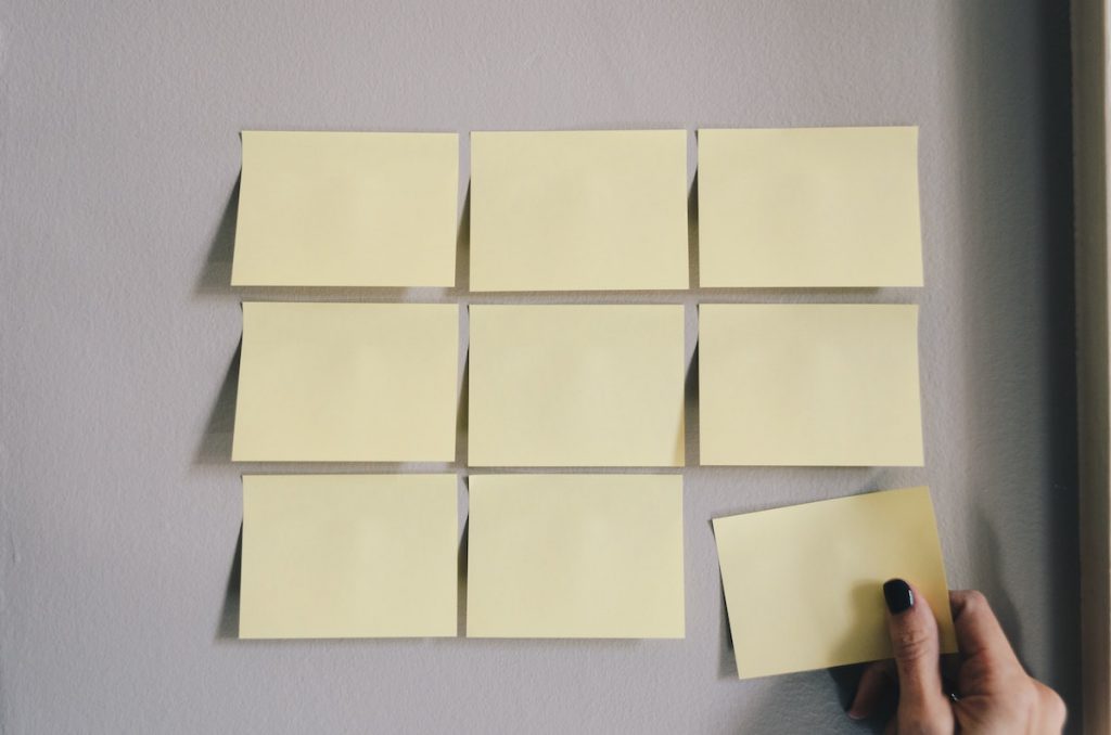 girl putting post-it notes up on a wall